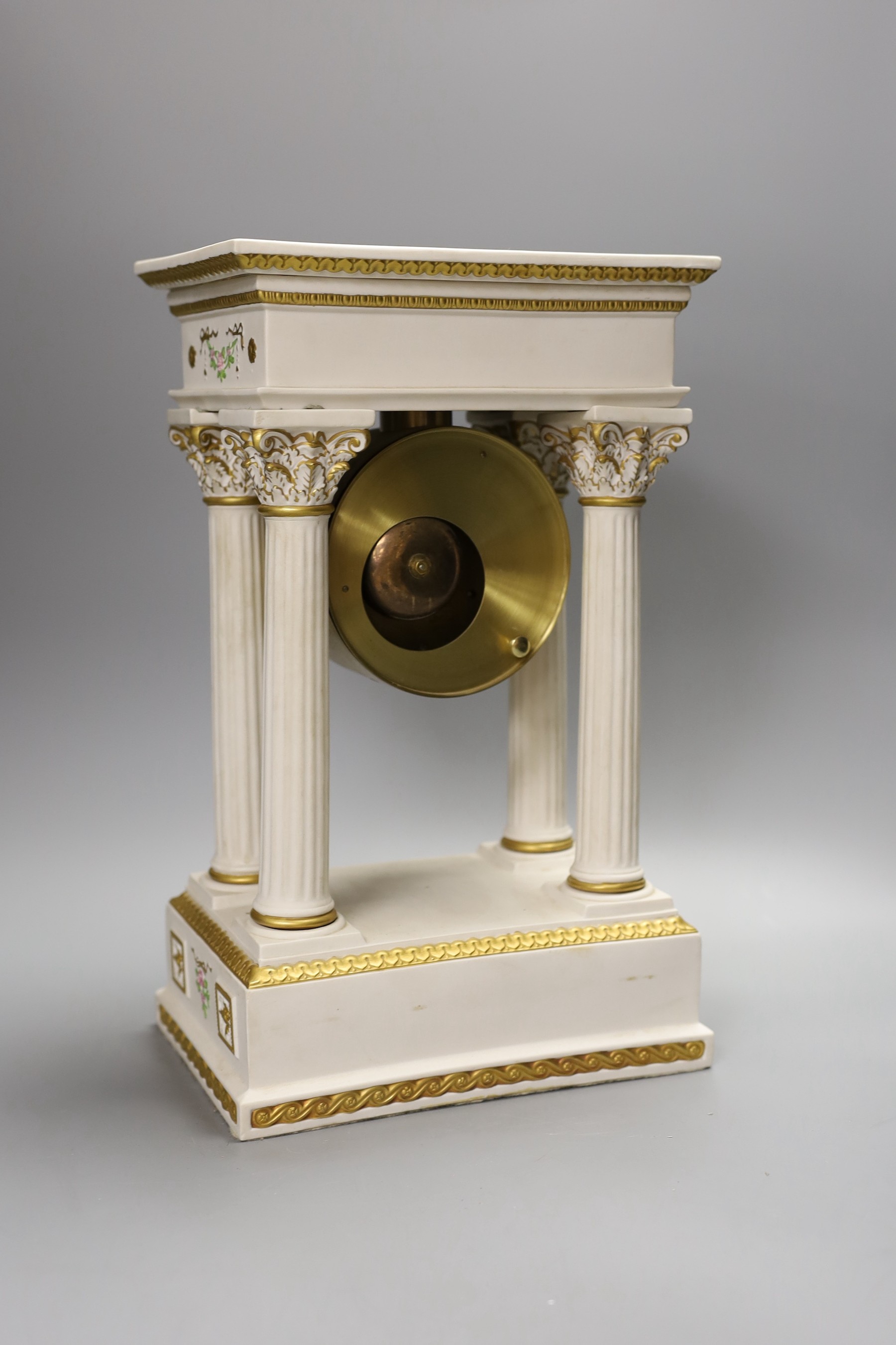 A modern ceramic portico column clock with floral and gilt decoration, with key and pendulum, 37cm tall